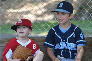 2 young baseball players in the dugout