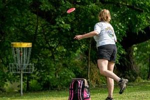 Woman tossing frisbee at goal